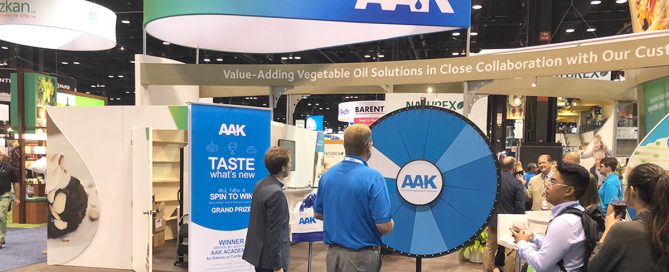 man and woman stand near a tradeshow booth