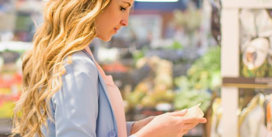 woman looking at grocery label