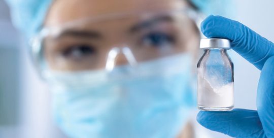 woman holding bottle of powder in lab