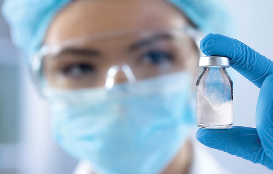 woman holding bottle of powder in lab