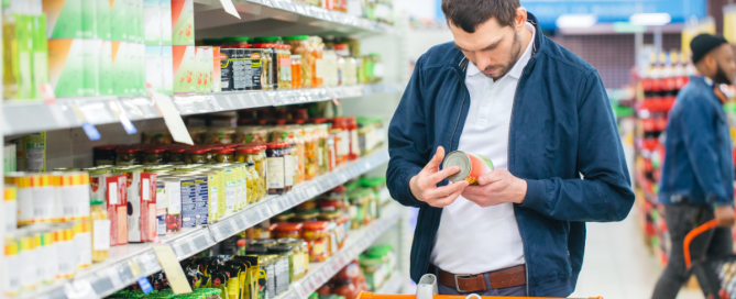 man reading label in grocery store