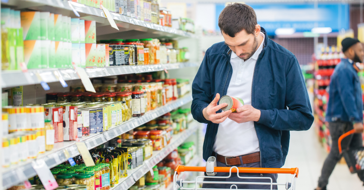 man reading label in grocery store