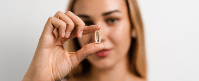 woman holding pill infront of face